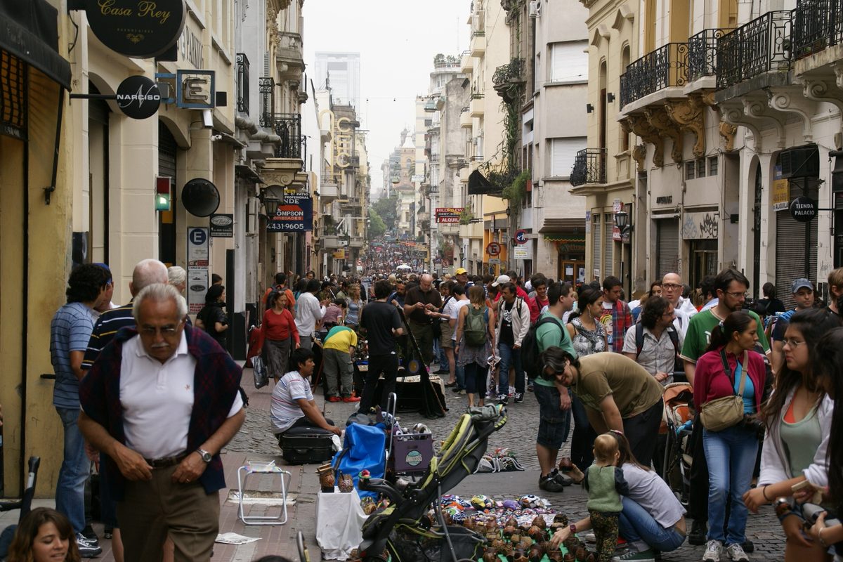 Crowds browsing the Sunday flea market along historic cobblestone Defensa street in San Telmo, the atmospheric old quarter among Buenos Aires areas for tourists