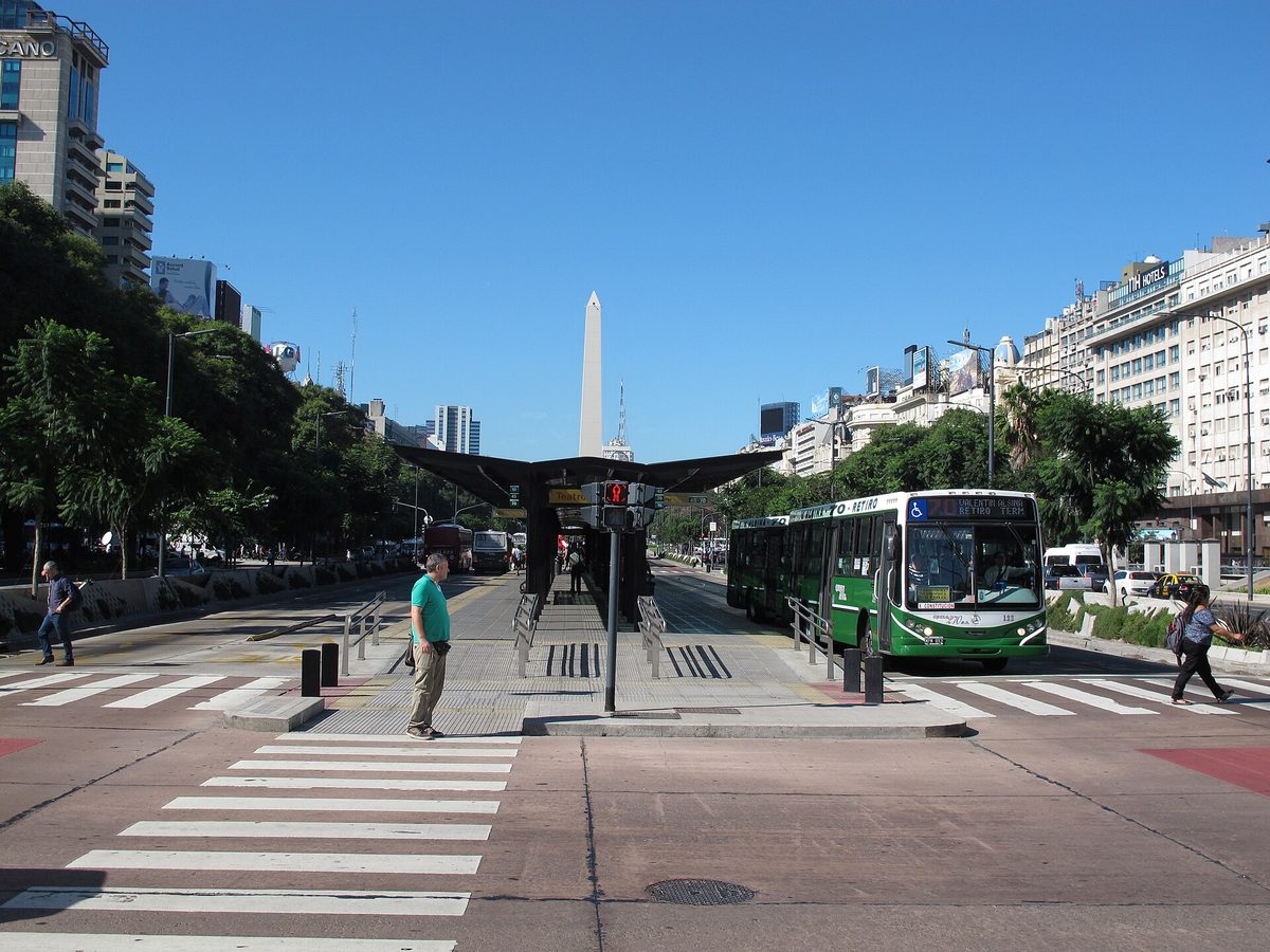 Green colectivo buses on the Metrobus lanes of Avenida 9 de Julio with the Obelisco behind, Buenos Aires