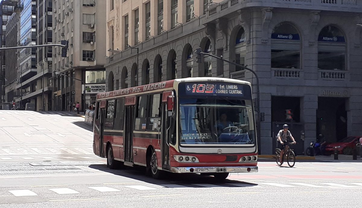 A red and white colectivo on line 109 turning a corner in downtown Buenos Aires