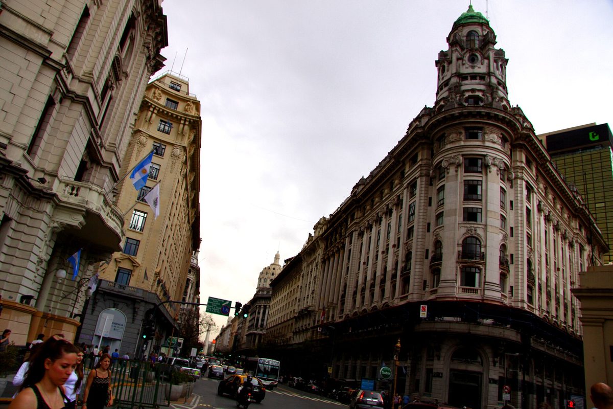 A grand Belle Epoque street corner in central Buenos Aires under soft spring skies
