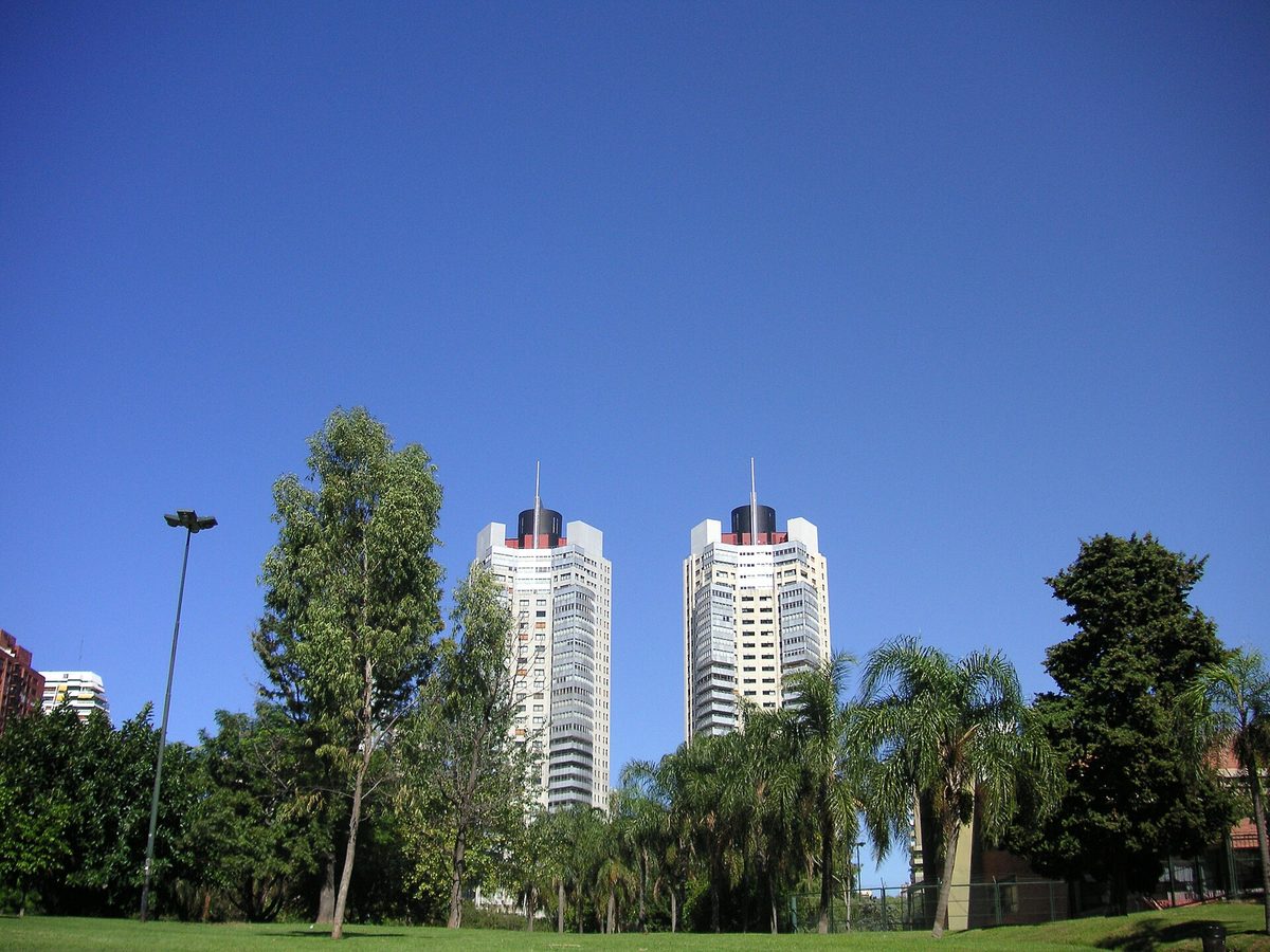 Shaded green lawns and palm trees under a blue sky in the Palermo parks, a popular spot to cope with Buenos Aires summer heat