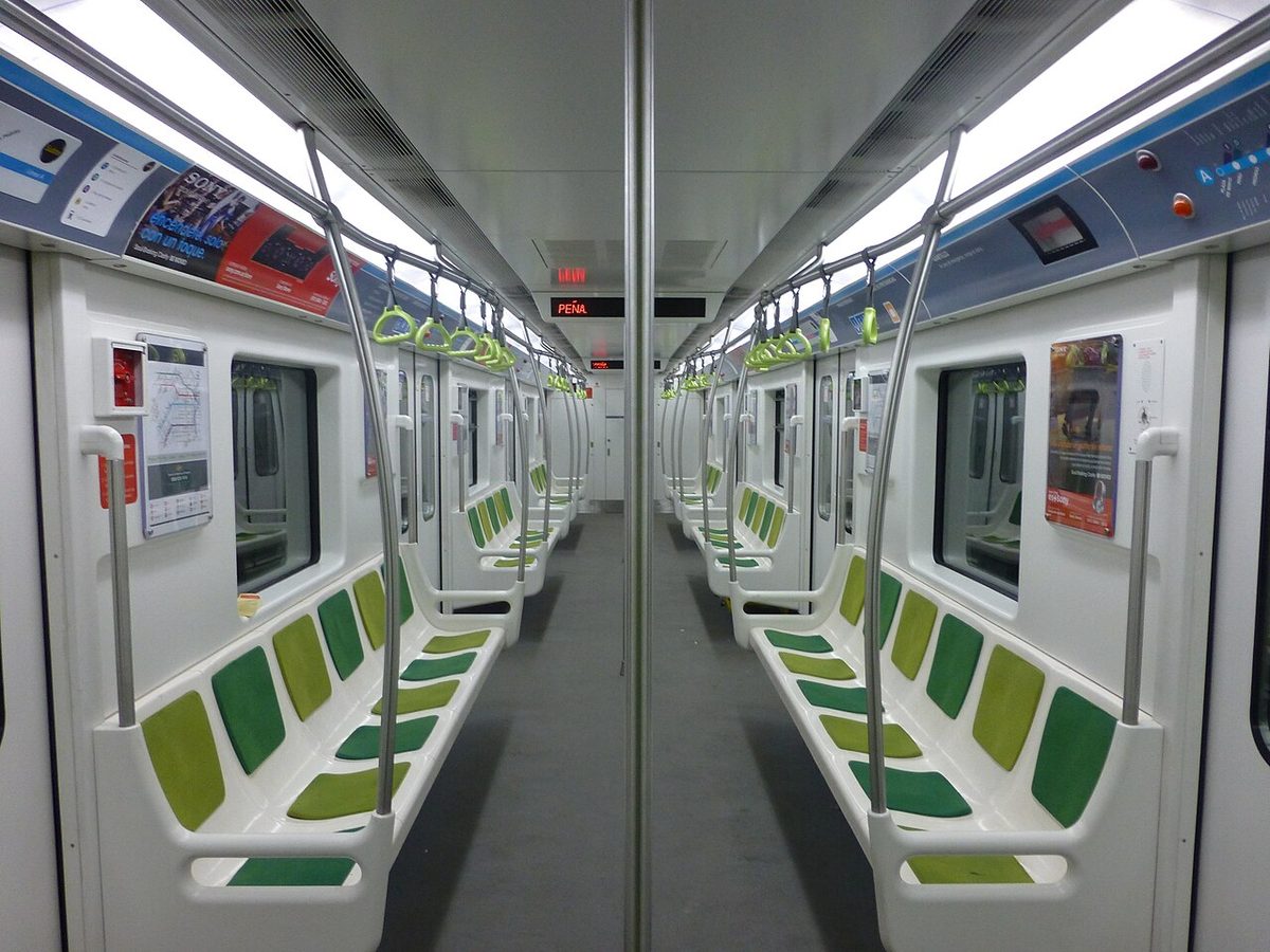 Interior of a modern Buenos Aires Subte car with green seats and overhead handholds, shown in this buenos aires subte guide