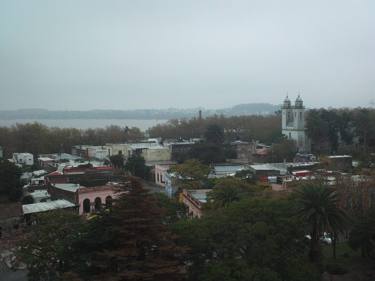 View over the red rooftops and church tower of Colonia del Sacramento with the Rio de la Plata behind