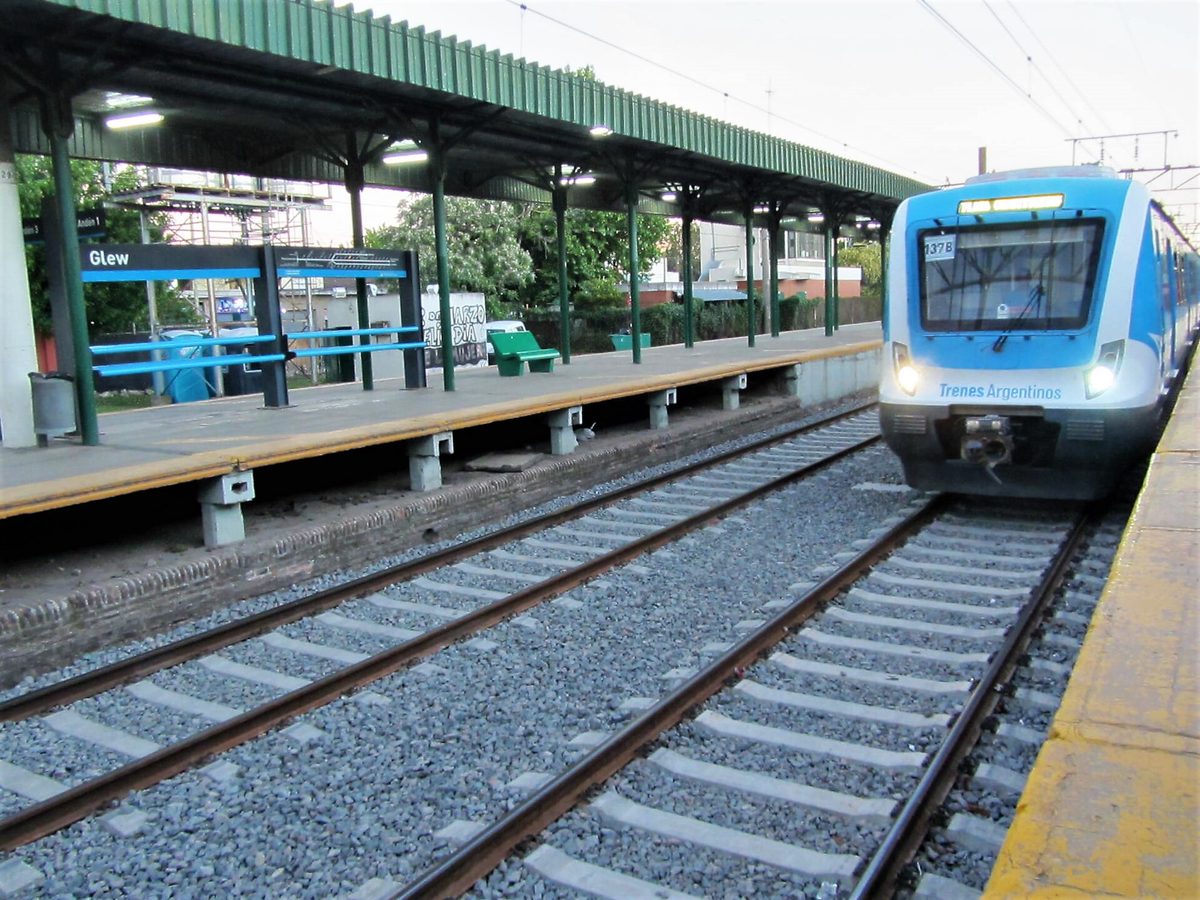 A modern blue-and-white Trenes Argentinos commuter train arriving at Glew station on the Roca line near Buenos Aires