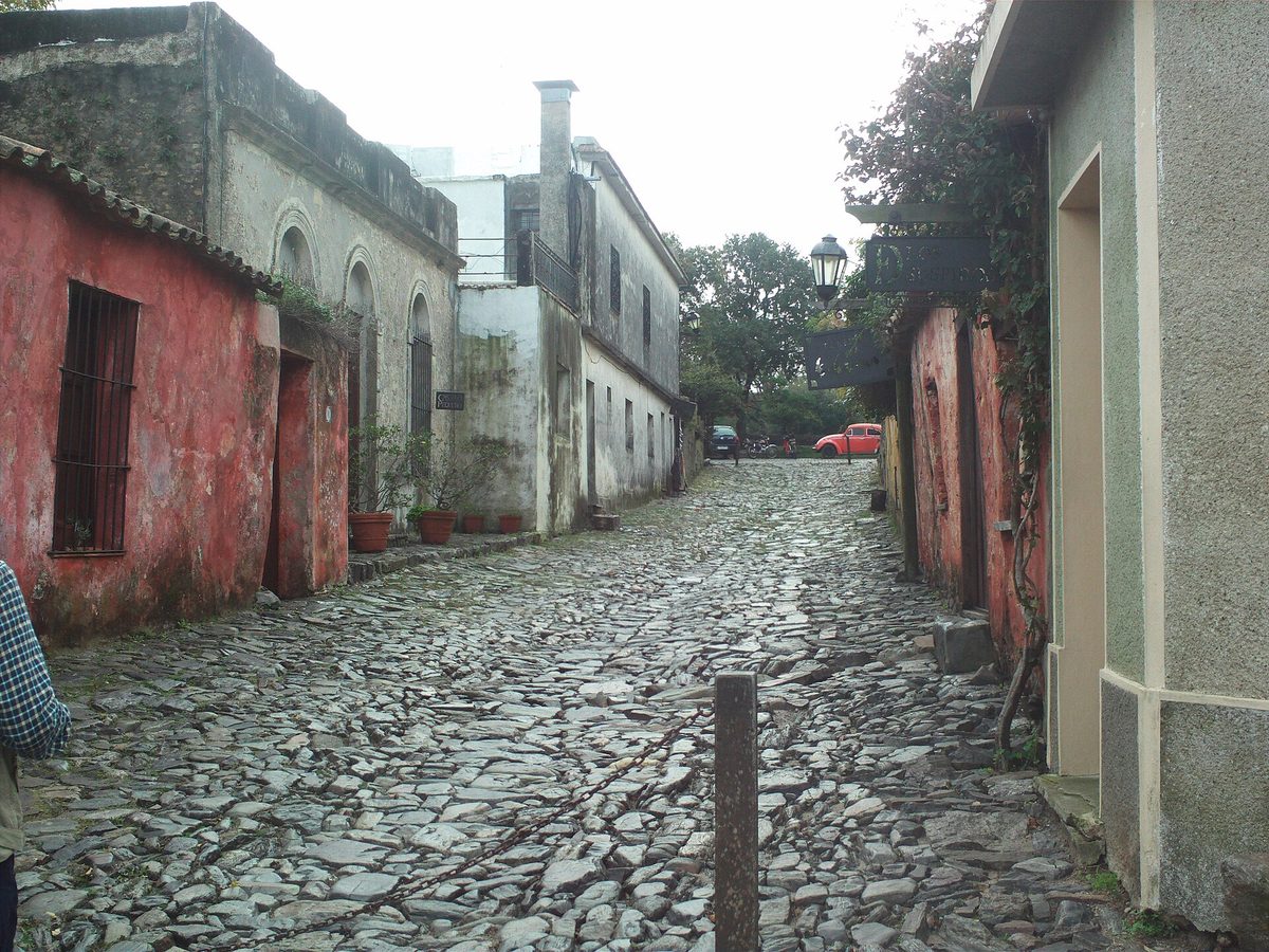 Cobblestone colonial street lined with rose-coloured houses in the Barrio Histórico of Colonia del Sacramento