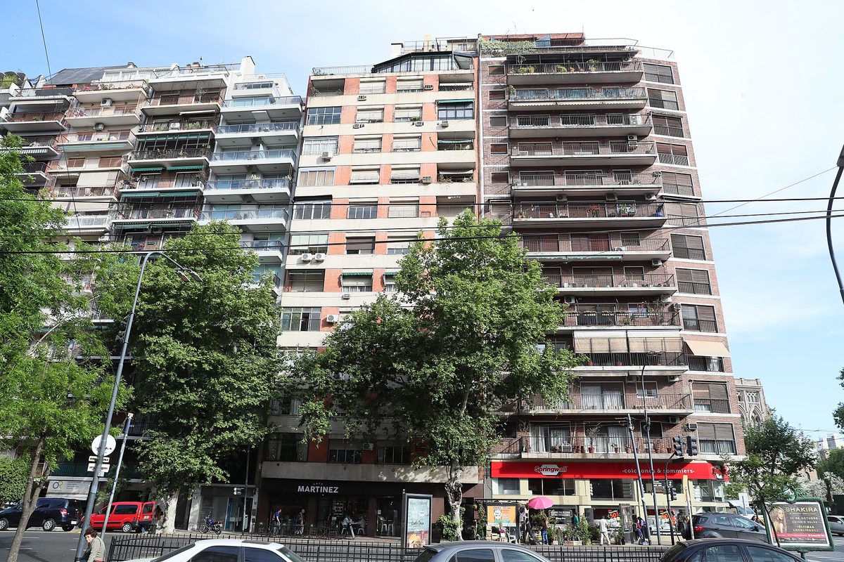 Tall residential apartment buildings lining a busy tree-shaded avenue in Recoleta, Buenos Aires