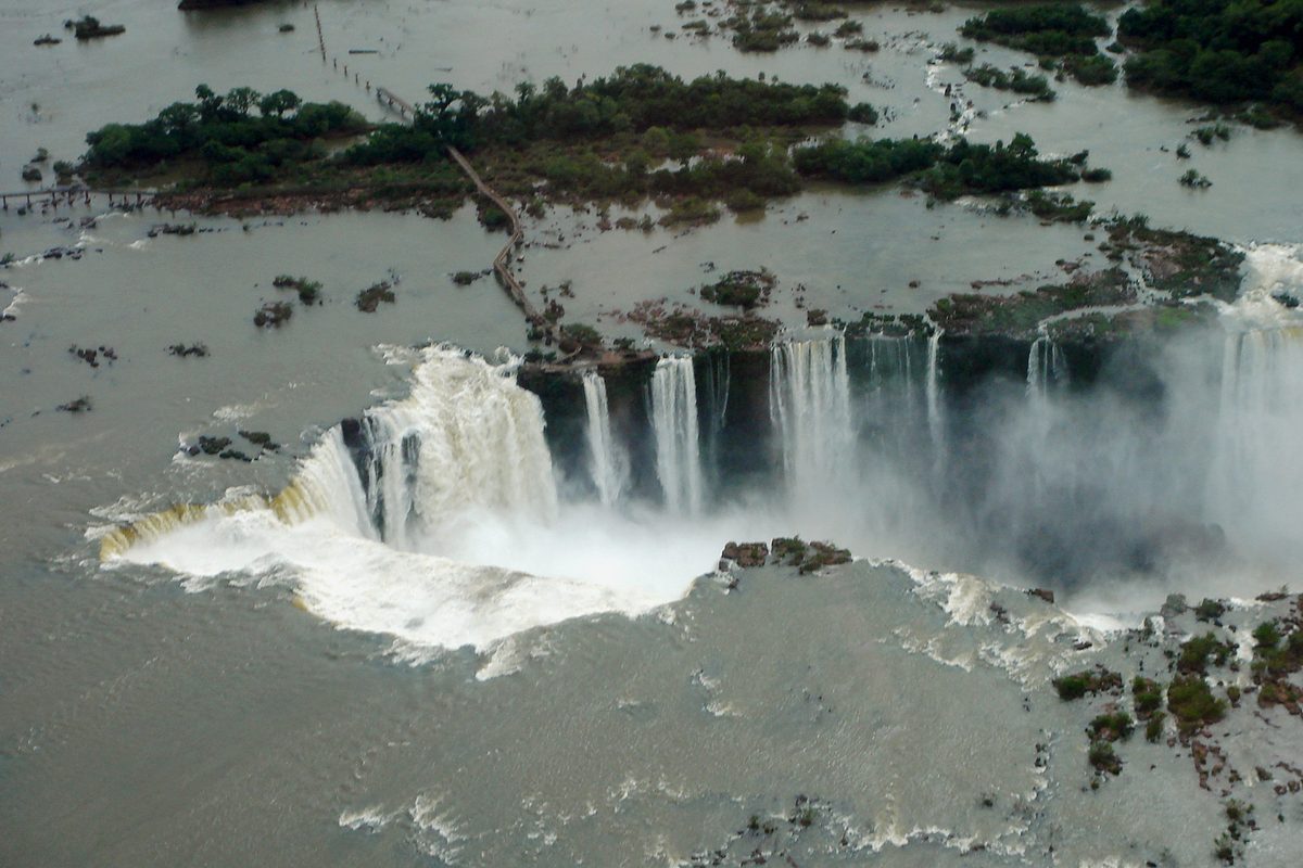 Aerial view of Iguazu Falls showing the long elevated walkway snaking across the river to the Garganta del Diablo viewpoint