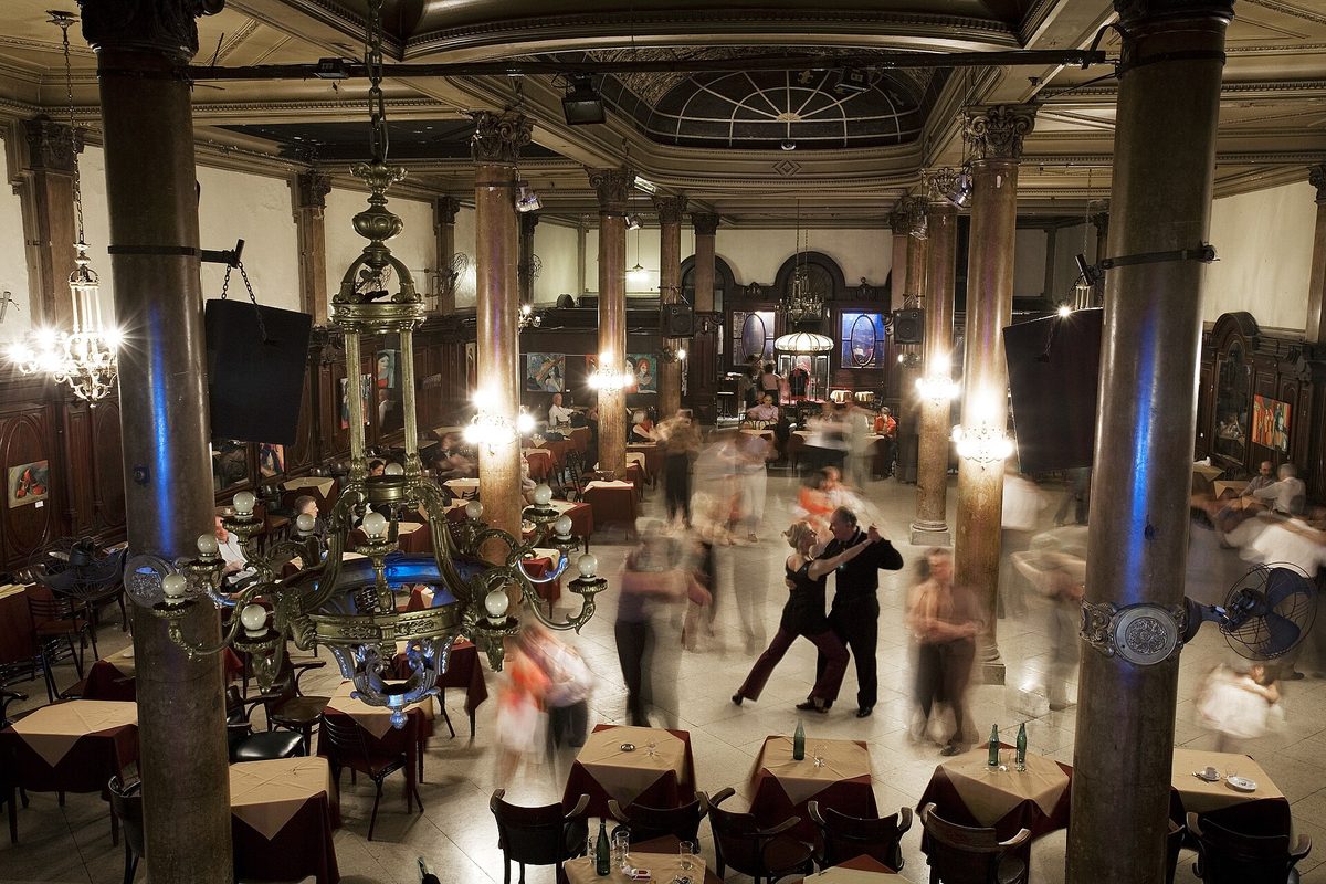 A milonga Buenos Aires dancers love: couples on a chandelier-lit tango ballroom floor