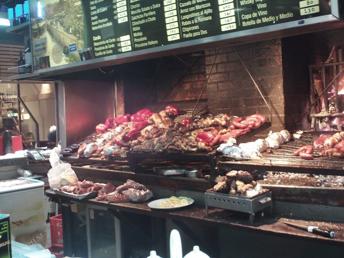 Parrilla grills piled with meat at the Mercado del Puerto in Montevideo, the place for an asado lunch