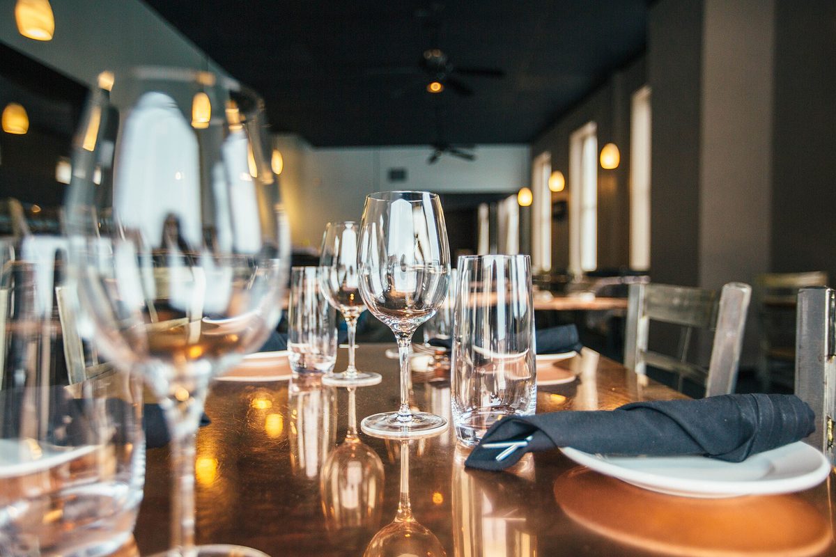 A candlelit table set with wine glasses for an intimate puertas cerradas buenos aires dinner