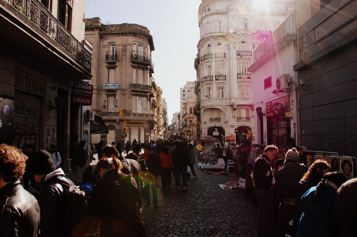 Crowds and antique stalls along cobbled Defensa street at the Sunday market in San Telmo buenos aires