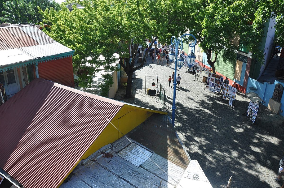 The colourful pedestrian Caminito street in La Boca seen from above, with corrugated-iron conventillo rooftops