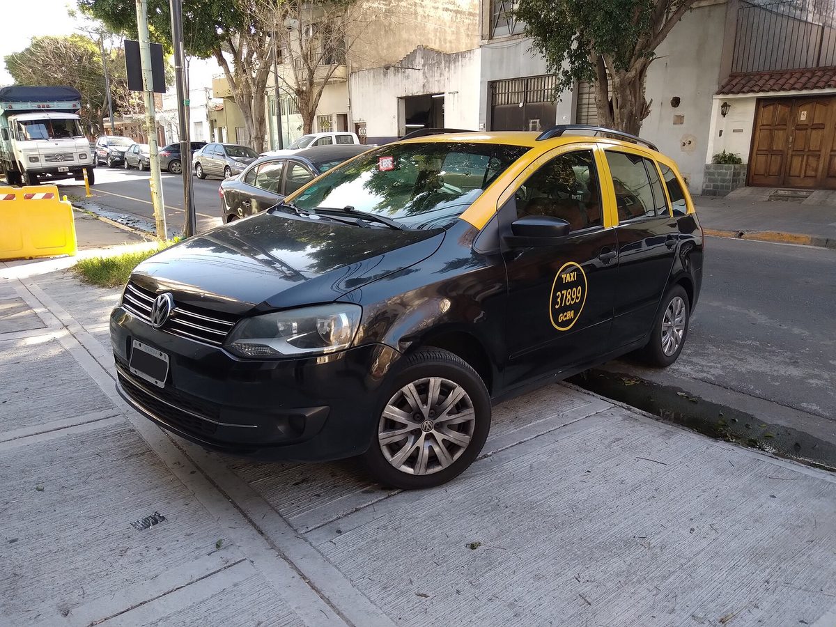 A black-and-yellow Buenos Aires taxi parked on a residential street